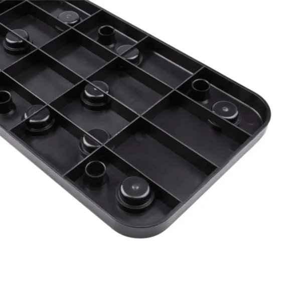 Black plastic tray with circular indentations and grid pattern.