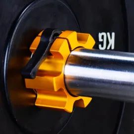 A yellow olympic barbell collar attached to a barbell sleeve