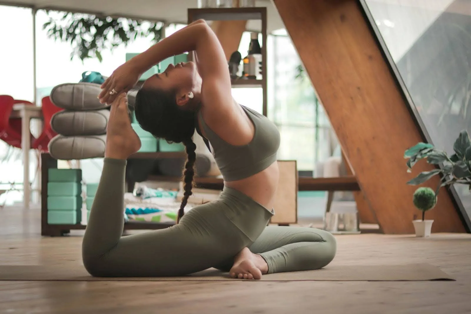 Person practicing yoga in a modern studio with natural light.